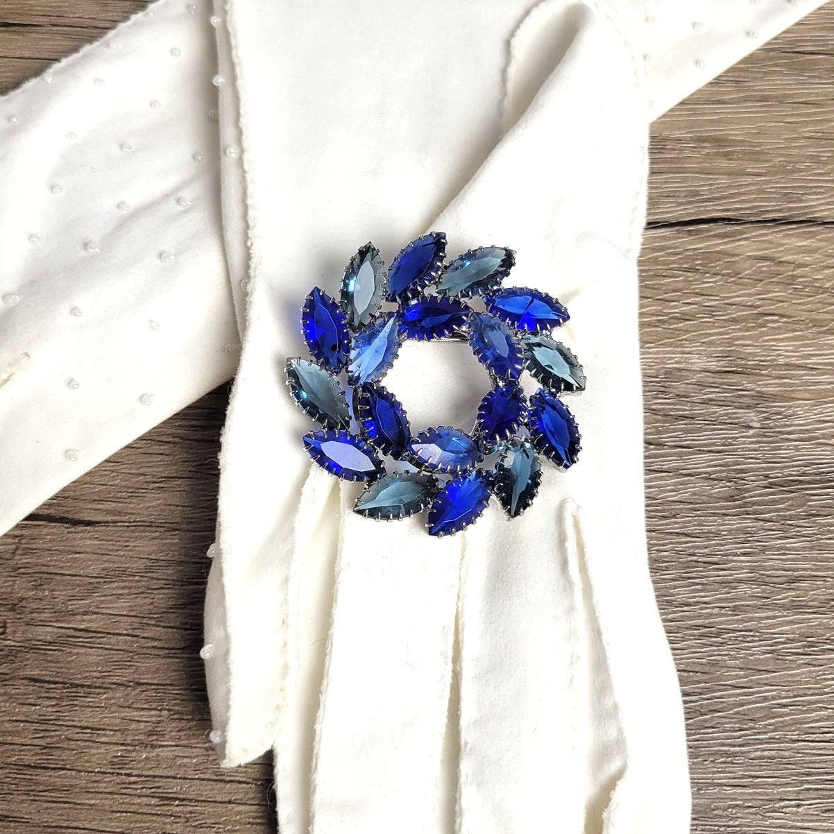 Vintage brooch blue glass open-back rhinestone circle or wreath dogtooth prongs